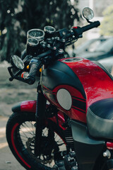 A red and black motorcycle featuring a retro design, detailed gauges, and a stylish fuel tank,...