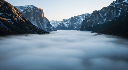 Spectacular view of a valley filled with dense fog and snow-capped mountains
