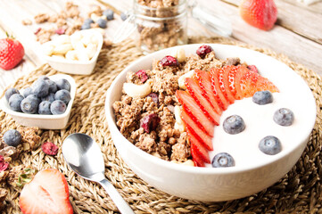 Muesli with organic berries and nuts. Oat muesli with raspberry, blueberry, strawberries, almond, cashew, banana. Healthy food, top view