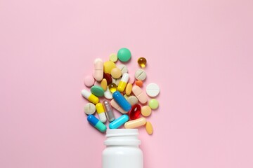 Various pills with white bottle on color background, top view