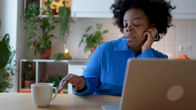Tired sleepy black woman remote worker truing to focused procrastinating during long workday with laptop. Frustrated african american female feeling bored, burnout, unmotivated while working from home