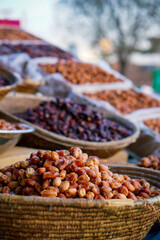 A close-up of fresh and dried dates displayed in woven baskets at a market.
