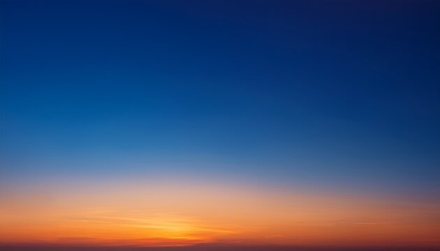 深い青から暖かいオレンジに変わるグラデーションの夕焼け空