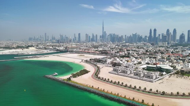 Dubai, United Arab Emirates: Aerial view of modern city skyline taken from Jumeirah, beach and financial district with skyscrapers on horizon - landscape panorama of Arabian Peninsula from above

