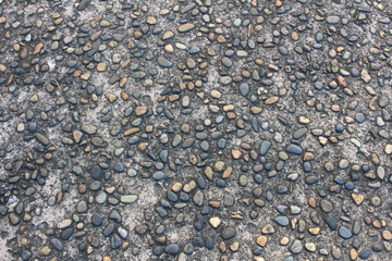 Gravel stones background. Pebbles embedded in concrete. Colorful pebble stone floor texture.