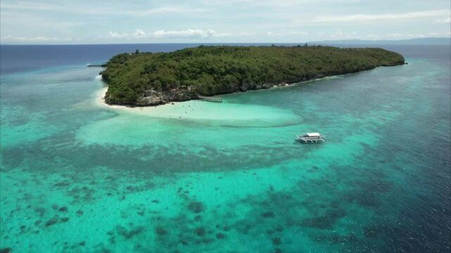 Aerial view of Sumilon Island, Philippines, showcasing a stunning sandbar and vibrant coral reef surrounded by turquoise waters. The contrast between the white sand and crystal-clear ocean highlights 