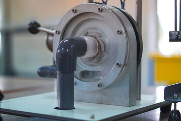 Close-up view of an industrial machine with metallic components, pipes, and mechanical parts used for scientific or engineering applications.