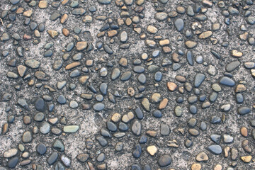 Close up of gravel stones background. Pebbles embedded in concrete. Colorful pebble stone floor texture.
