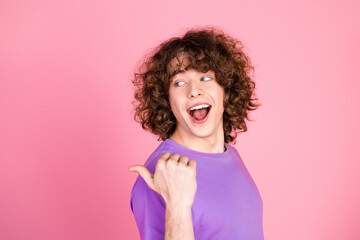 Cheerful Young Man Expressing Joy with a Playful Gesture Against a Vibrant Pink Background