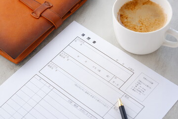 就職活動（就活）のために、コーヒーを飲みながら、履歴書を作成する
