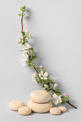 Wood slice podium and and blossoming branches of apple tree on gray background. Concept scene stage showcase for new product, banner, promotion sale, cosmetic, presentation. Spring concept