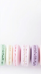 Colorful macarons in purple, yellow, pink, and green, arranged horizontally on a white background, minimal style. 