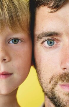 Close-up half portrait of a father and son's faces side by side