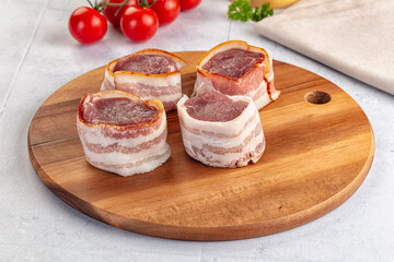 Raw pork tenferloin with bacon