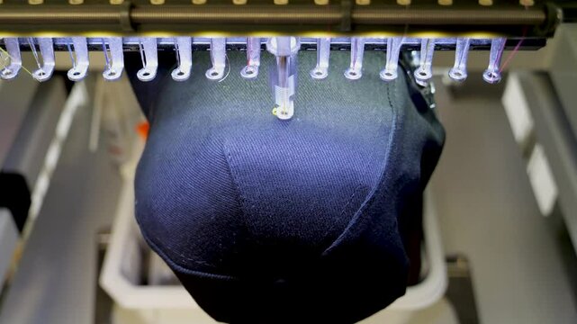 Machine embroidery of stars on a black hat with yellow thread. Embroidered baseball cap close-up. 4k 50 fps video.