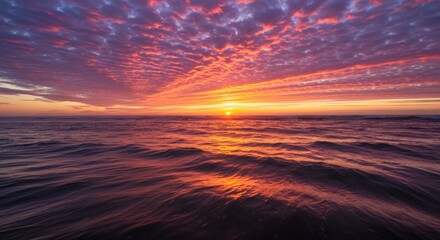 Obraz premium Stunning sunset over calm ocean waters with vibrant clouds reflecting warm colors