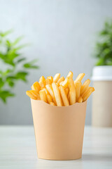 Golden french fries in a light brown paper container on a white table