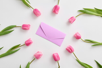 Tulips are elegantly arranged around a purple envelope symbolizing love, gratitude and the joy of...