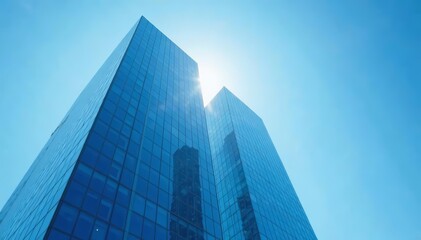 Naklejka premium Modern glass skyscraper reflecting sunlight with clear blue sky background, architecture, office building, exterior