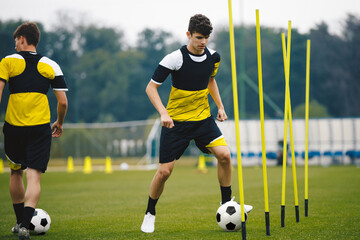 Junior Football Club Practice Session. Teenagers in Soccer Training Sportswea. Sports Educational Equipment. Youth Sports Player Running With Soccer Ball on Training Field.