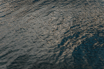 Background, texture of water from a river, sea, ocean with ripples on the surface.