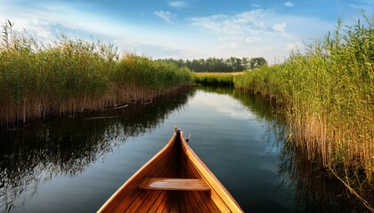 wooden rowboat alone on calm river surrounded by reeds