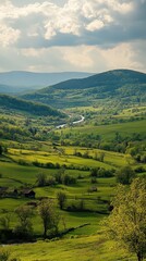 Obraz premium A lush green valley stretches wide, dotted with vibrant wildflowers, as a sparkling river meanders gracefully through the landscape, reflecting the clear blue sky above.