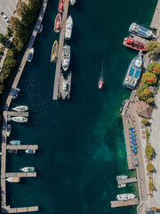 Aerial drone 90 degree straight down photo of marina with clear emerald water with moored tour and...