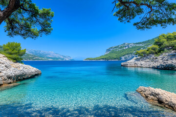 Secluded cove with crystal-clear turquoise water, framed by lush greenery under a vibrant blue sky