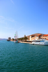 Fototapeta premium Beautiful old buildings, boats and yachts on the promenade in Trogir, Croatia. Sunny summer day in Trogir.