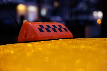 Brightly lit taxi cab in a rainy urban landscape at twilight, showcasing vibrant colors and reflections