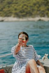 Portrait of a young girl drinking champagne in a boat.