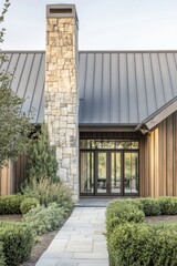 The entrance of this charming modern house features a beautiful blend of stone and wood siding, nestled in a tranquil landscape setting illuminated by soft evening light