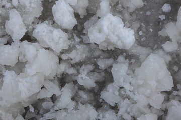 Rough uneven chunks of frozen snow on the surface of the ice. Abstract background with copy space....