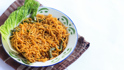 a bowl of fried noodles, with mustard greens, chili and tomatoes, sweet and spicy noodles, isolated. mie goreng, mie ayam, bihun. suitable for menu books, advertisements and recipes.
