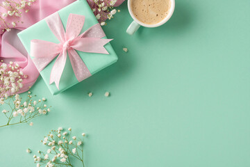 Pastel-colored gift box adorned with a ribbon surrounded by flowers, with a coffee cup on a...