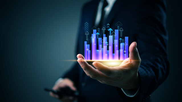 Businessman holding glowing bar chart with upward arrows, symbolizing business growth, financial success, data analytics, investment forecast and digital strategy.