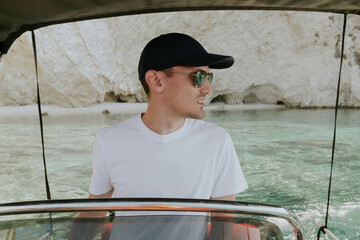 A young guy controls a boat on the sea.
