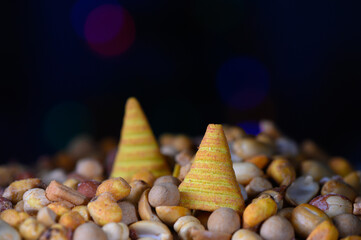Colorful conical treats surrounded by a variety of vibrant nuts and seeds in a festive atmosphere