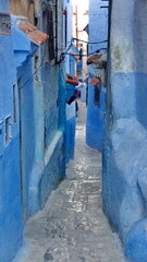Narrow alley with blue walls in the medina in Chefchaouen, Morocco