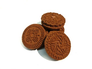 Chocolate biscuits with cream in the middle on a white background.