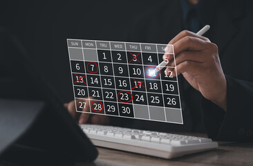 Digital scheduling and event planning concept. Businessman uses stylus to mark important dates on a...