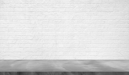 empty grey plaster concrete table top in foreground with white plaster brick wall at background. counter bar foreground can be used for display or montage products in industrial mood and tone.