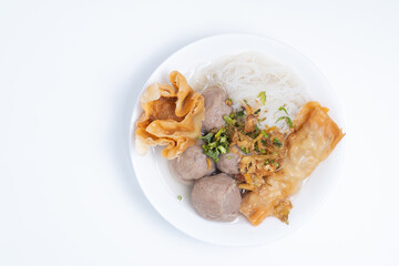 A white bowl of Bakwan Malang, featuring meatballs, noodles, fried wontons, and tofu in a clear broth. A savory and flavorful Indonesian soup.