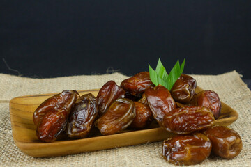 Dried date palm fruits or kurma on wooden plate for breakfasting in ramadhan. popular and healthy dates