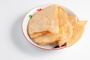 A bowl of Krupuk Udang (prawn crackers), a crispy Indonesian snack.  it's a savory and popular appetizer.