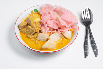 A vibrant plate of Lontong Sayur, an Indonesian rice cake and vegetable stew, is presented with a spoon and fork, highlighting the flavors of Southeast Asian cuisine.