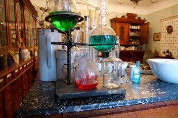 Chemistry beakers,bottles and flasks with liquids in laboratory of old pharmacy