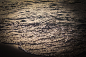 backlit sea texture at sunset. The water's surface is textured with small ripples and waves background