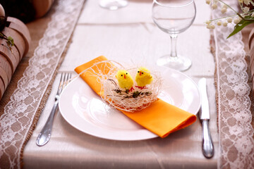 Easter table setting in yellow colors with yellow napkins, nests and chickens